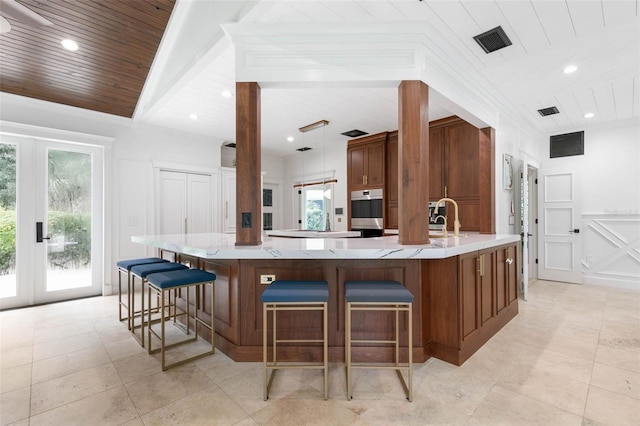 kitchen with a large island, hanging light fixtures, sink, and a wealth of natural light