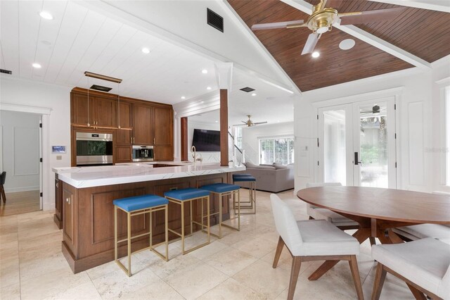 kitchen featuring ceiling fan, appliances with stainless steel finishes, lofted ceiling, and wooden ceiling