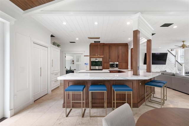 kitchen featuring ceiling fan, a spacious island, and a breakfast bar