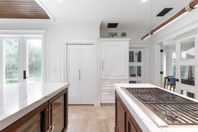 kitchen featuring wood ceiling, ornamental molding, light stone countertops, and a wealth of natural light