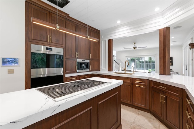 kitchen featuring light stone counters, ceiling fan, appliances with stainless steel finishes, and sink