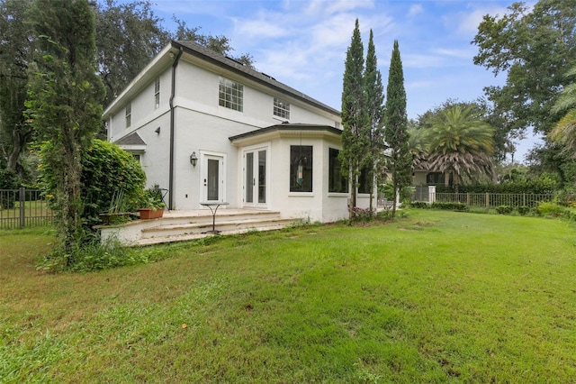 back of house with a lawn, a patio area, and french doors