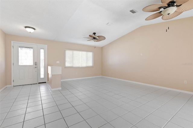 foyer entrance with lofted ceiling, light tile patterned floors, and ceiling fan