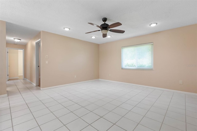 empty room with a textured ceiling, ceiling fan, and light tile patterned floors