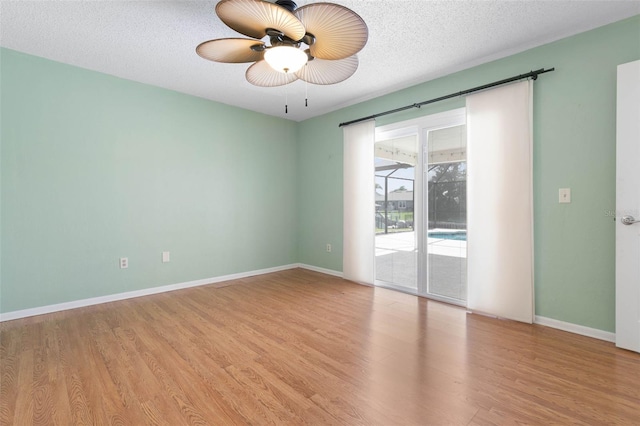 empty room with a textured ceiling, light hardwood / wood-style flooring, and ceiling fan