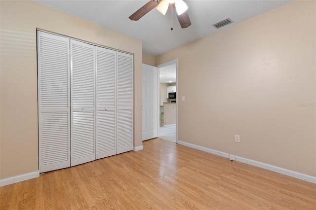 unfurnished bedroom featuring a textured ceiling, ceiling fan, a closet, and light hardwood / wood-style floors