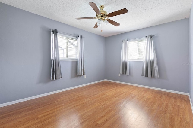 empty room with hardwood / wood-style floors, ceiling fan, and a textured ceiling