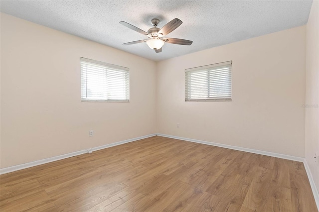 unfurnished room with light wood-type flooring, ceiling fan, a textured ceiling, and a healthy amount of sunlight