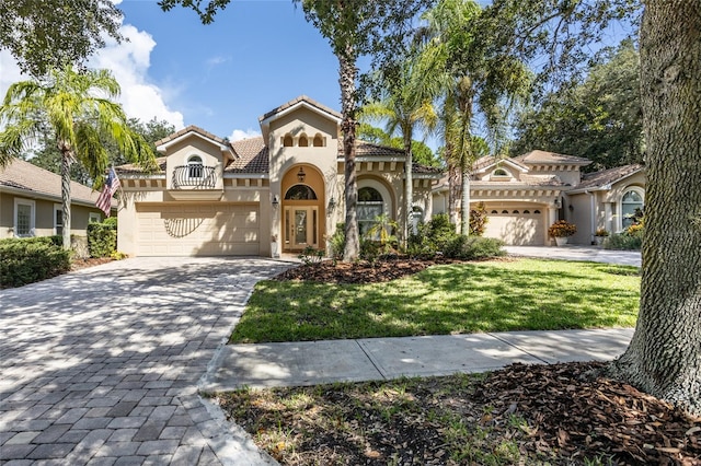 mediterranean / spanish-style home with a garage and a front lawn