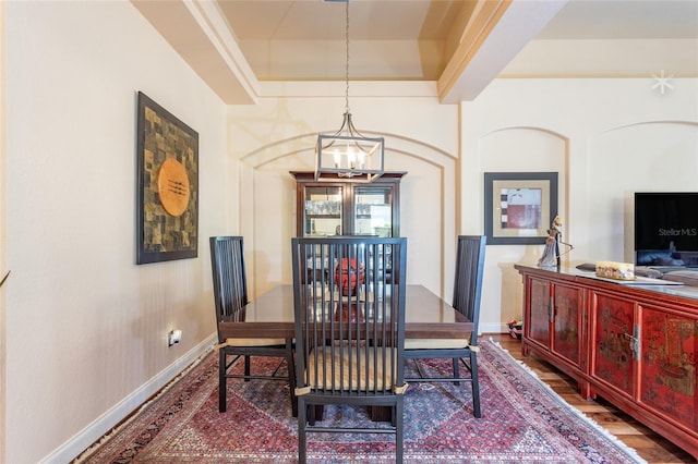 dining room featuring a notable chandelier, hardwood / wood-style floors, and a tray ceiling