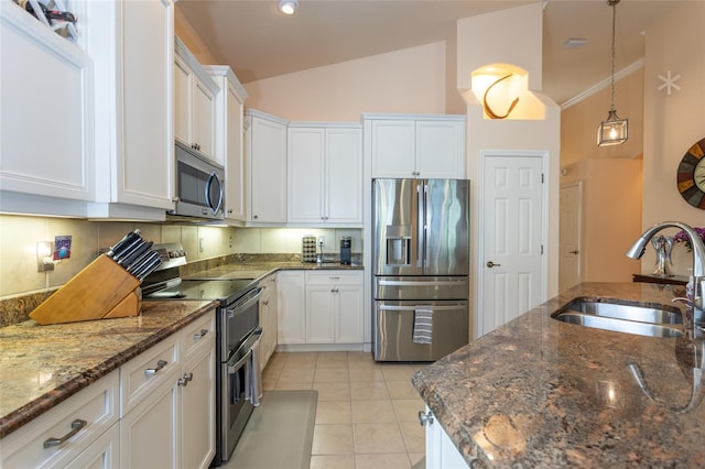 kitchen featuring white cabinets, decorative light fixtures, stainless steel appliances, sink, and lofted ceiling