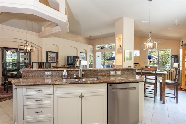 kitchen featuring light tile patterned floors, sink, stainless steel dishwasher, and white cabinets