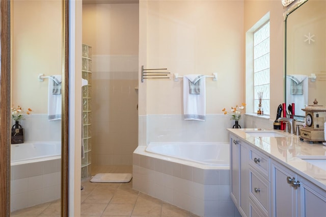 bathroom featuring plus walk in shower, tile patterned flooring, and vanity