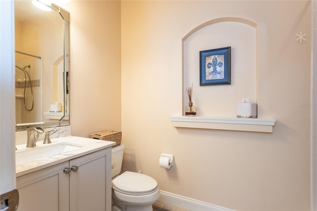 bathroom featuring a shower, toilet, and vanity