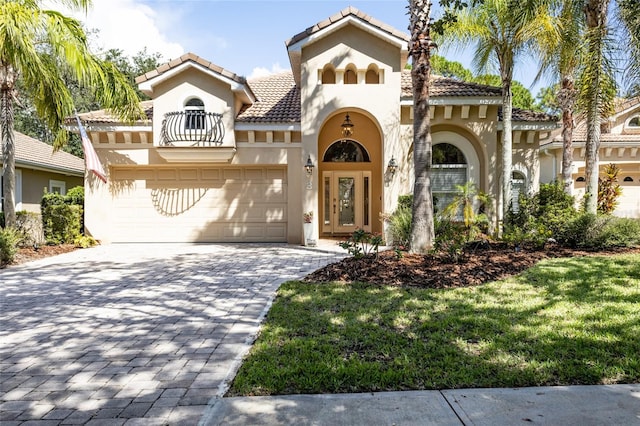 mediterranean / spanish-style home with a garage, french doors, and a front lawn