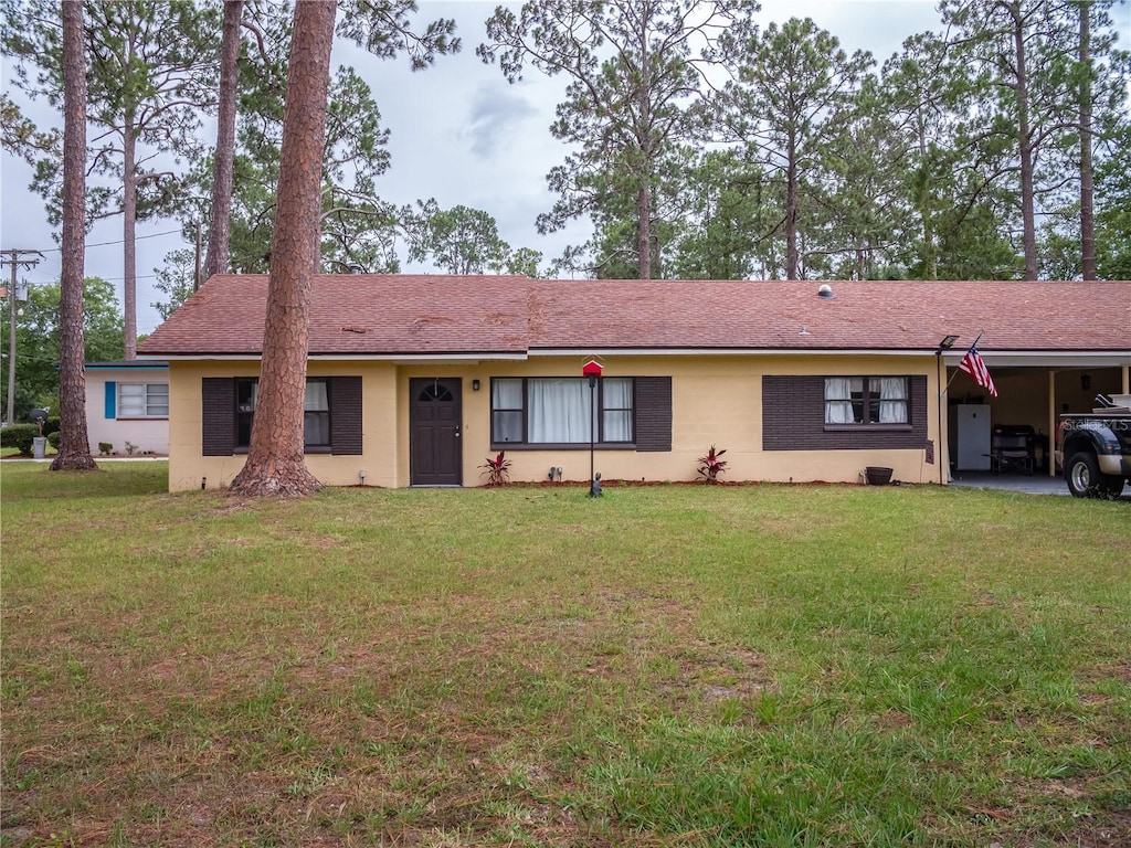 362 E Minnesota Ave, Macclenny, FL 32063 - ranch-style home with a front lawn, an attached carport, and stucco siding
