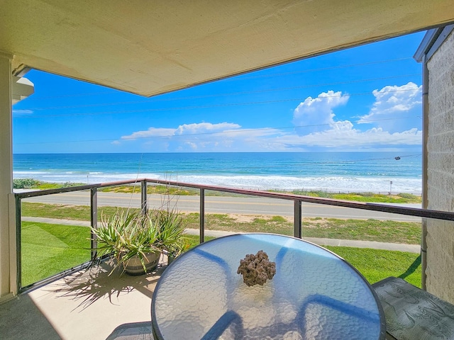 balcony featuring a water view and a beach view