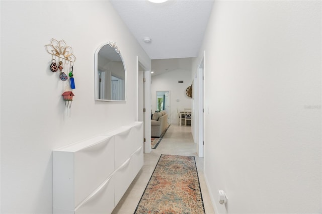 hallway featuring a textured ceiling and lofted ceiling