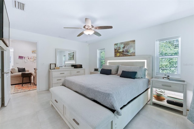 bedroom featuring visible vents, ceiling fan, and light tile patterned floors