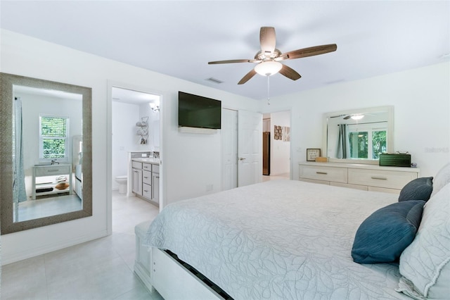 bedroom with a ceiling fan, light tile patterned floors, visible vents, and connected bathroom