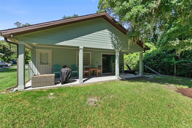 rear view of house with a patio area and a yard