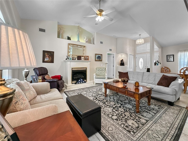 living room featuring ceiling fan with notable chandelier and high vaulted ceiling