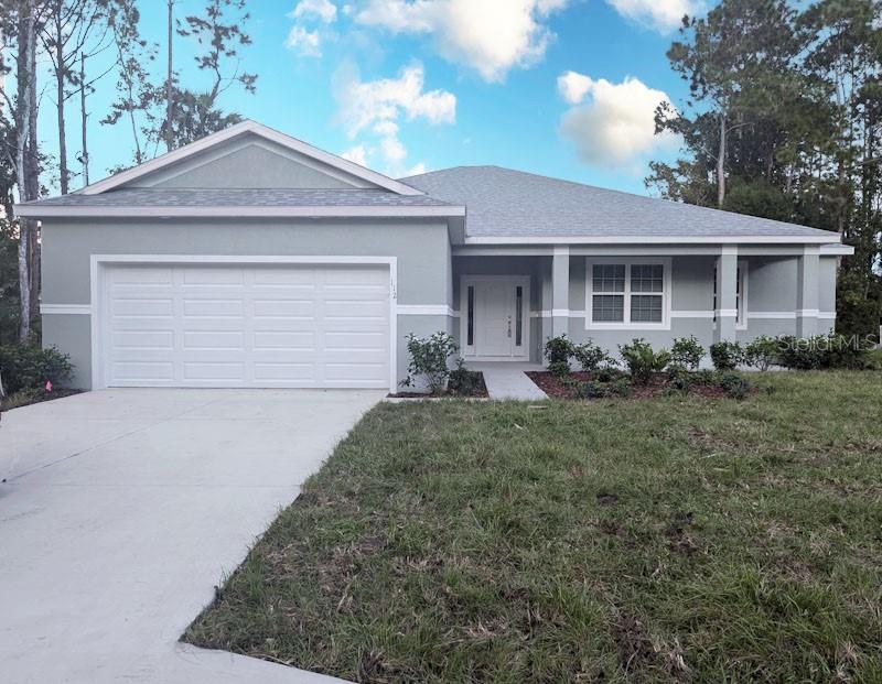 single story home with a garage and a front yard