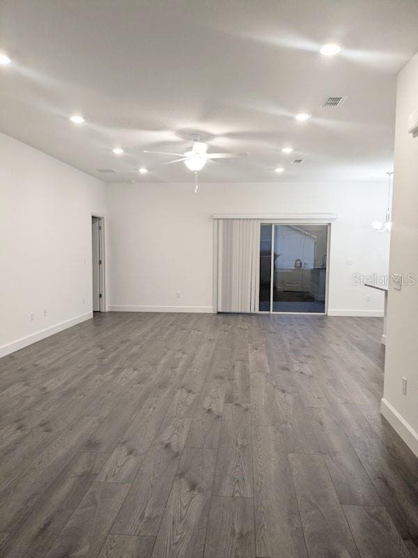 unfurnished living room with ceiling fan and dark hardwood / wood-style floors