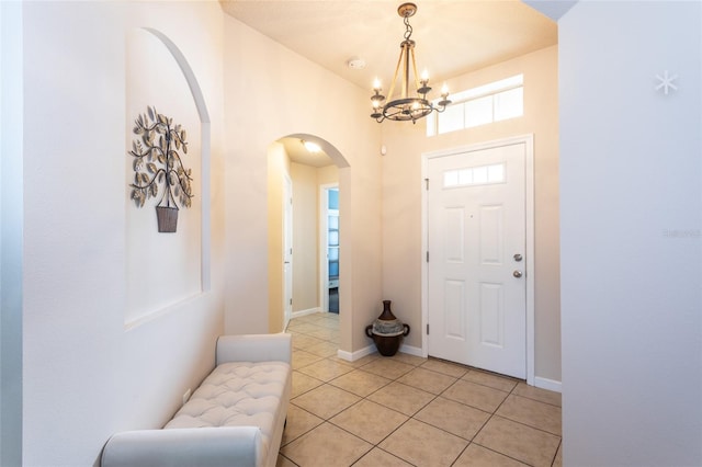 foyer entrance with an inviting chandelier and light tile patterned floors