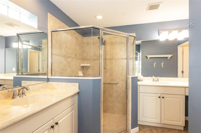 bathroom featuring tile patterned floors, vanity, and a shower with shower door