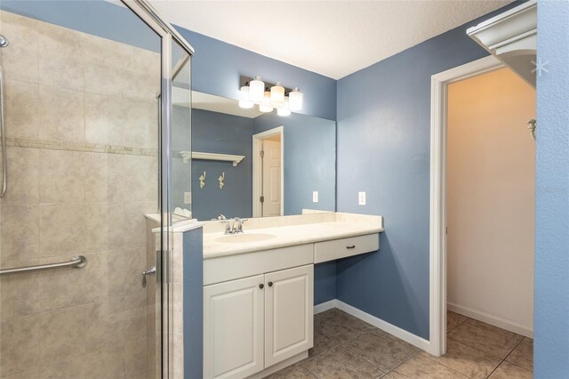 bathroom with vanity, a shower with shower door, and tile patterned floors