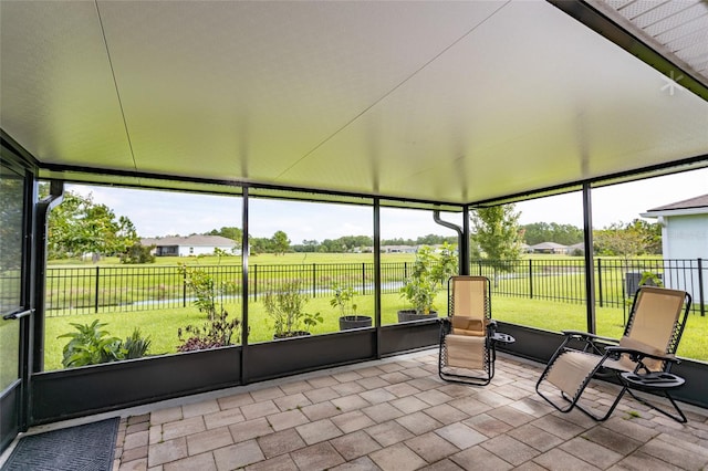 unfurnished sunroom featuring a water view and a healthy amount of sunlight