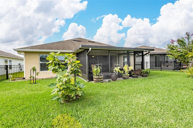 back of property with a yard and a sunroom