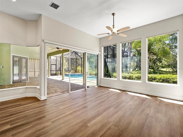 unfurnished sunroom featuring ceiling fan