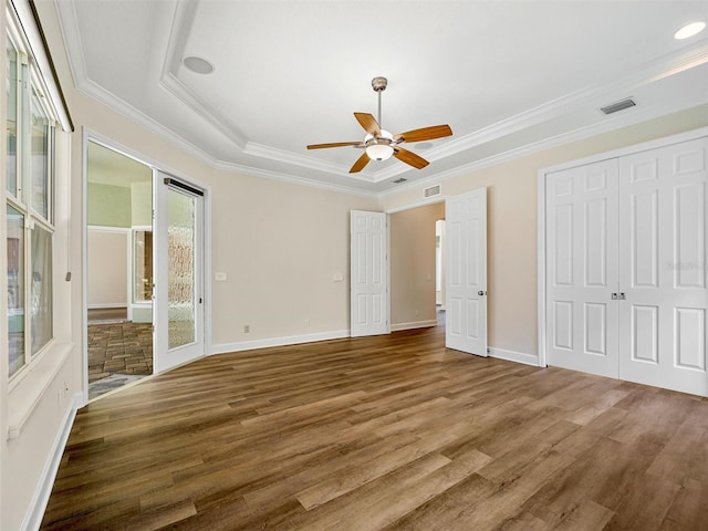 unfurnished bedroom with hardwood / wood-style flooring, crown molding, a raised ceiling, access to outside, and ceiling fan