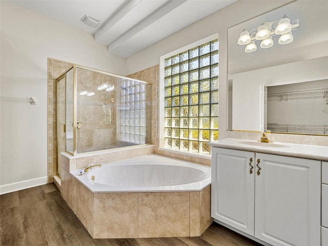 bathroom with vanity, hardwood / wood-style floors, and plus walk in shower