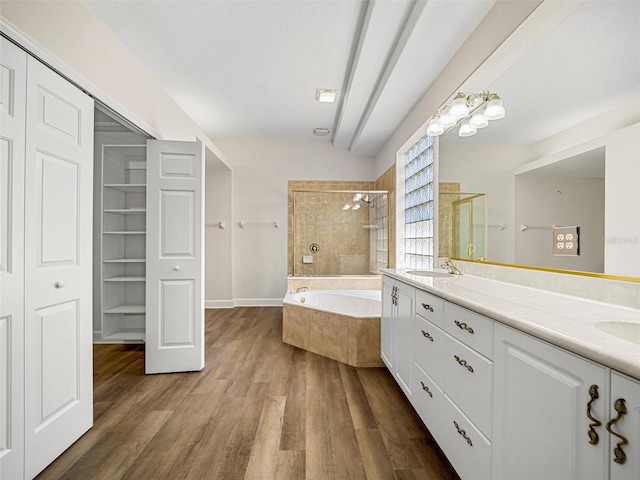 bathroom featuring hardwood / wood-style flooring, shower with separate bathtub, and vanity