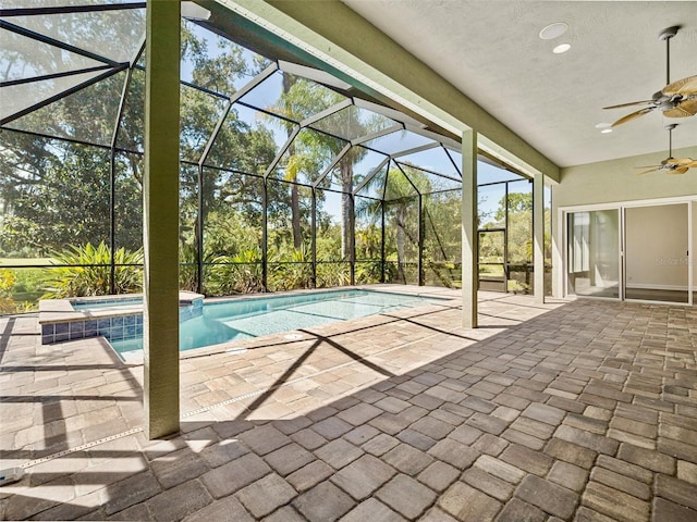 view of pool with a lanai, an in ground hot tub, ceiling fan, and a patio