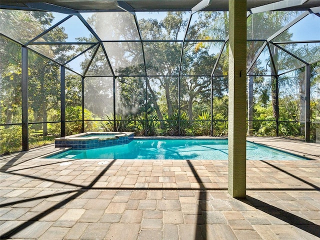 view of pool with a lanai, an in ground hot tub, and a patio