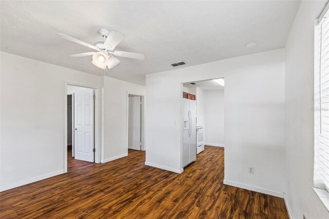 unfurnished bedroom featuring white refrigerator with ice dispenser, ceiling fan, and dark hardwood / wood-style flooring