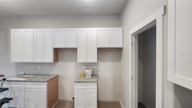 kitchen with light stone counters and white cabinetry