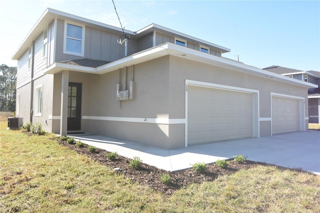 view of front of property featuring an attached garage, central air condition unit, driveway, stucco siding, and board and batten siding