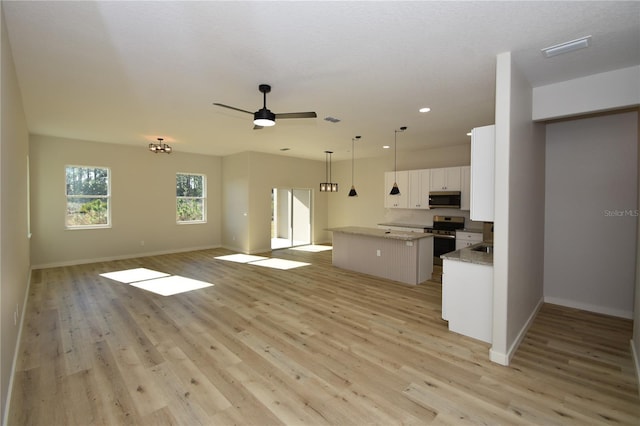 kitchen with light wood-style flooring, stainless steel appliances, white cabinets, open floor plan, and a center island