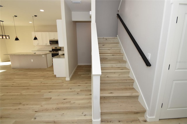 stairs featuring baseboards, wood finished floors, visible vents, and recessed lighting