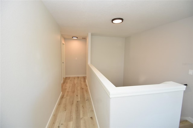 hall featuring light wood finished floors and baseboards