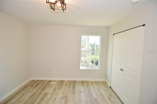 unfurnished bedroom with light wood-type flooring, a closet, and baseboards