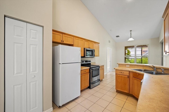 kitchen featuring light tile patterned floors, decorative light fixtures, appliances with stainless steel finishes, sink, and high vaulted ceiling