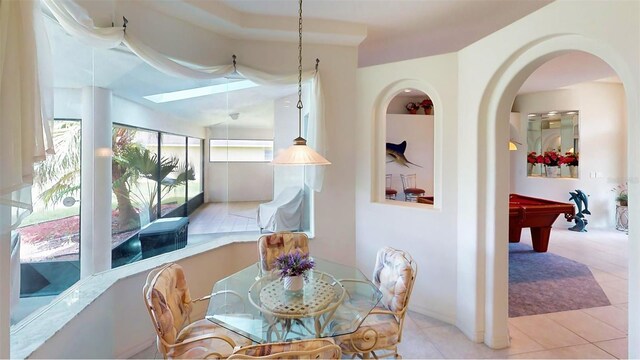 dining area featuring a skylight, light tile patterned floors, and pool table