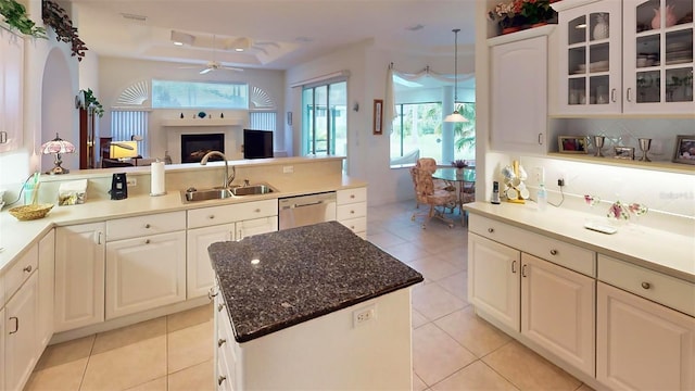 kitchen featuring light tile patterned floors, dishwasher, a center island, sink, and ceiling fan