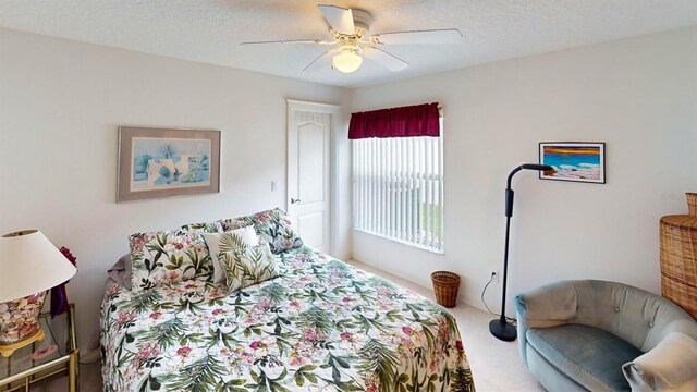 bedroom featuring carpet flooring, ceiling fan, and a textured ceiling